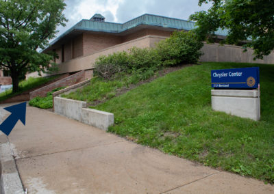 Exterior of Chrysler Center and an arrow pointing toward the door.