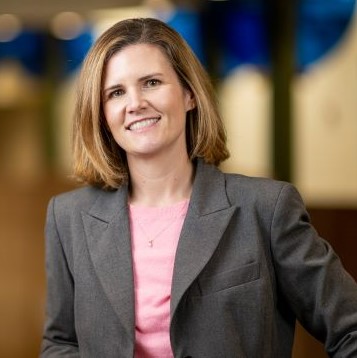 Women in blazer pink shirt smiling 